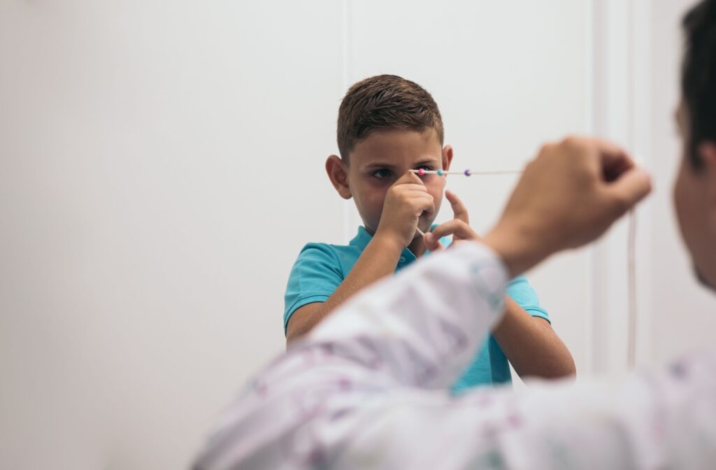 Young boy uses a brock cord as a visual therapy exercise with an optometrist.