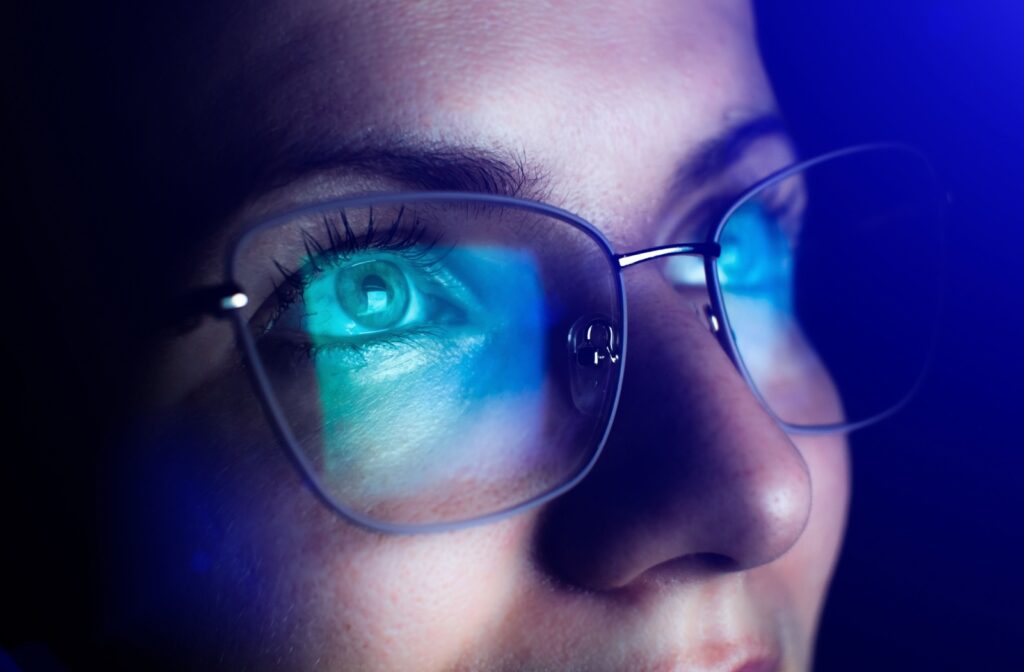 Close-up of blue light reflecting off lenses of computer glasses.
